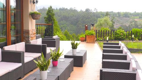 a patio with a bunch of chairs and plants at Hotel Rural Playa de Aguilar in Muros de Nalón