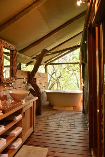 a bathroom with two sinks and a bath tub at Summerfields Rose Retreat and Spa in Hazyview