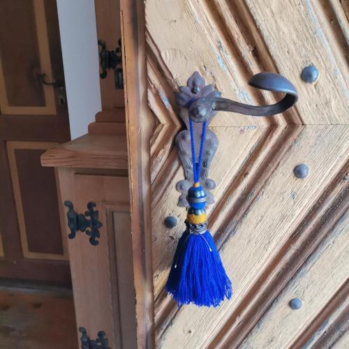 a blue tassel hanging from a wooden door at Bodenschmiede in Hopfgarten im Brixental