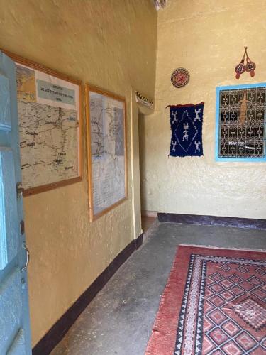 a room with a wall with maps and a rug at Gite d étape Khettara Oasis in Er Rachidia