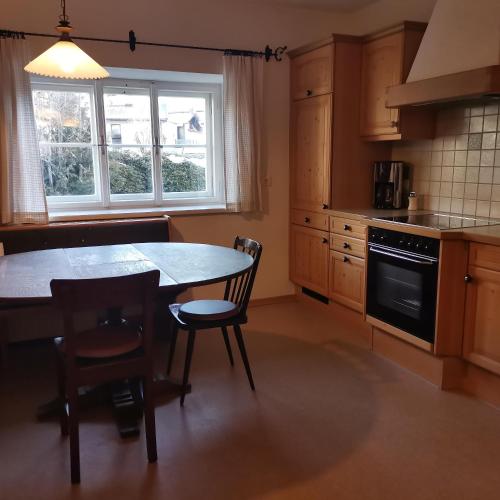 a kitchen with a table and chairs and a window at Bodenschmiede in Hopfgarten im Brixental