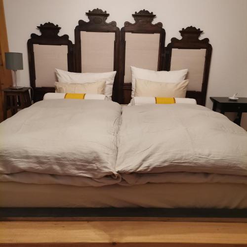 a large bed with white sheets and yellow pillows at Bodenschmiede in Hopfgarten im Brixental