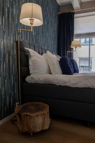a bedroom with a bed with pillows and a table at Stadslogies City Apartment Monsieur Philippe in Leeuwarden