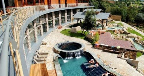 uma piscina no topo de um edifício com uma fonte em New J&J Hostel em Ourense