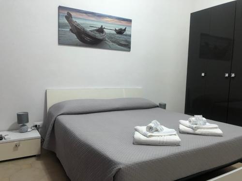 a bedroom with a bed and a picture of a boat at Solemare Beach Apartment Trapani in Erice