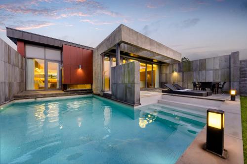 a house with a swimming pool in front of a house at STANFORD Hotel & Resort Jeju in Jeju