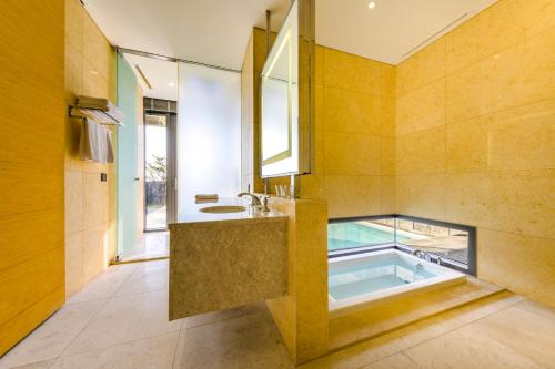 a bathroom with a tub and a sink at STANFORD Hotel & Resort Jeju in Jeju