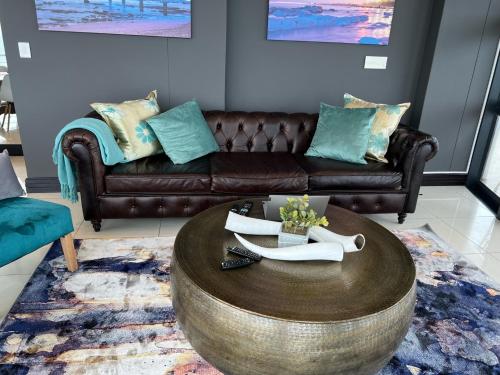 a living room with a leather couch and a coffee table at The Pearls of Umhlanga - Ocean view Apartments in Durban
