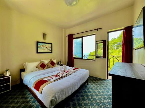 ナガルコットにあるHotel Sakura Durbarのベッドルーム1室(ピンクのタオルが付いたベッド1台付)