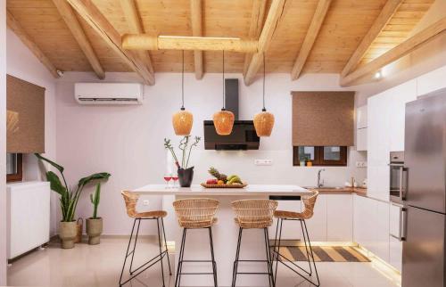 a kitchen with a island with bar stools at Villa Repsimia with Private Jacuzzi in Kókkinos Pírgos