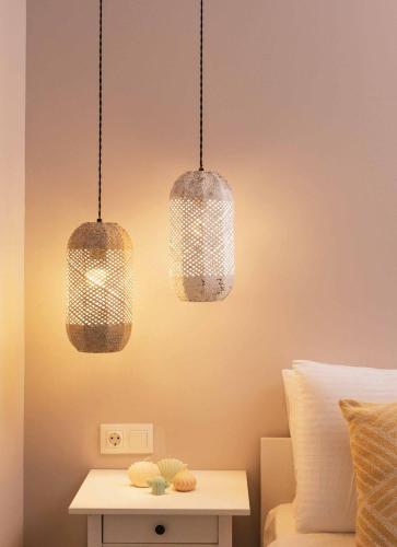 three lights hanging over a bed with a table at Villa Repsimia with Private Jacuzzi in Kókkinos Pírgos
