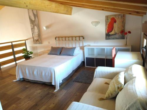 Las Gemelas 1 y 2 apartamentos turísticos في Cardeñosa: غرفة نوم بسرير واريكة في غرفة