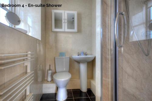 a bathroom with a toilet and a sink and a shower at The White House in Bridport