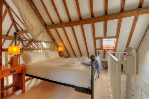 a bedroom with a large bed in a attic at The Forge in Rousdon