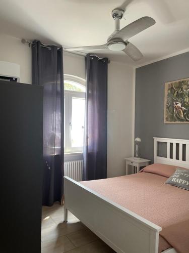 a bedroom with a bed with purple curtains and a window at IL CAPRICCIO DI SILVIA in Sirmione