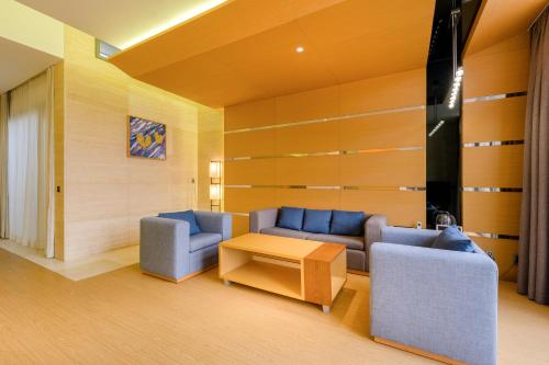 a living room with two couches and a table at STANFORD Hotel & Resort Jeju in Jeju