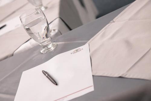 a white envelope with a pen and a glass at Hotel Estancia Chipichape Cali in Cali