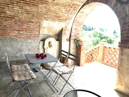 een tafel en stoelen op een balkon met een bakstenen muur bij Studio de charme avec grande terrasse vue mer in Le Castellet