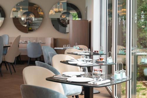 a restaurant with tables and chairs and mirrors at Hôtel Omnubo Collection in Les Épesses