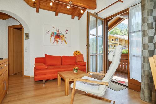 a living room with a red couch and a table at Ferienwohnung Lobenhofer in Reit im Winkl