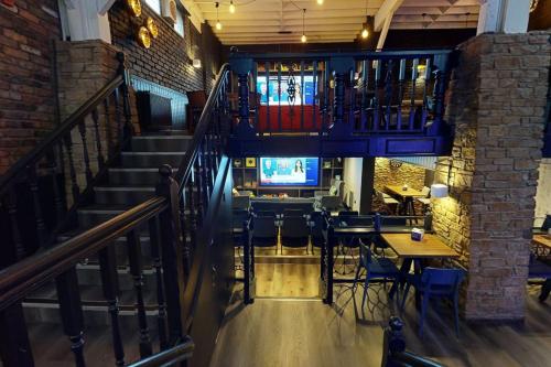 a staircase in a restaurant with tables and chairs at Village Hotel Manchester Hyde in Hyde