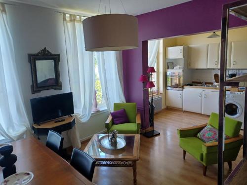 un salon avec des chaises vertes et une table dans l'établissement Demeure en Seine - Gîtes et chambres d'hôte en bord de Seine, à Caudebec-en-Caux