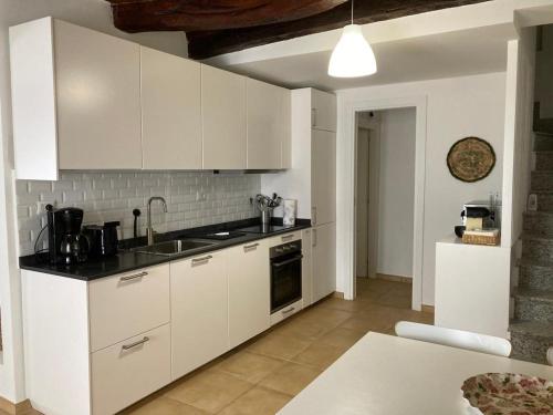 eine Küche mit weißen Schränken und einer Arbeitsplatte in der Unterkunft Casa Nonna Delfina in Tortolì