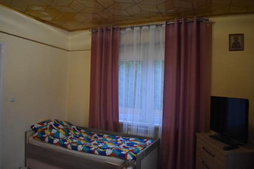 - une chambre avec un lit et une fenêtre avec des rideaux dans l'établissement Domek na wsi-agroturystyka, à Czyże