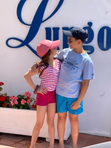 two young children standing in front of a sign at Hotel Lungomare in Vlorë