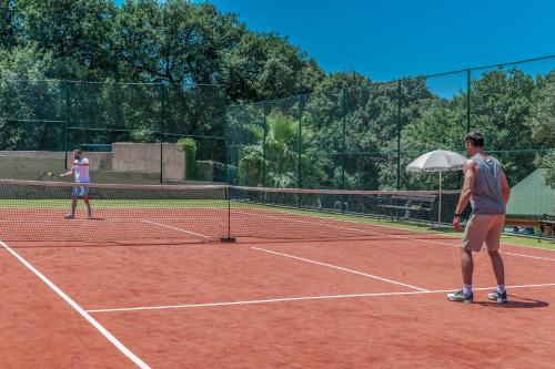 two men playing tennis on a tennis court at Radisson Resort Ruza Vjetrova in Dobra Voda