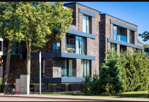 un bâtiment en briques avec un arbre devant lui dans l'établissement Apartamentų Nuoma MiniLiux, à Palanga