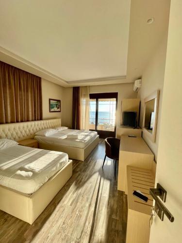 a hotel room with two beds and a desk at Hotel Lungomare in Vlorë