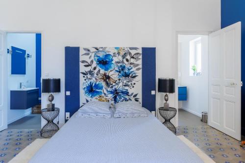 a bedroom with a large bed with blue walls at La Passerelle du Canal in Sallèles-dʼAude