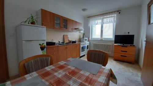 a kitchen with a table and a white refrigerator at Apartmán Jaruška in Týn nad Vltavou