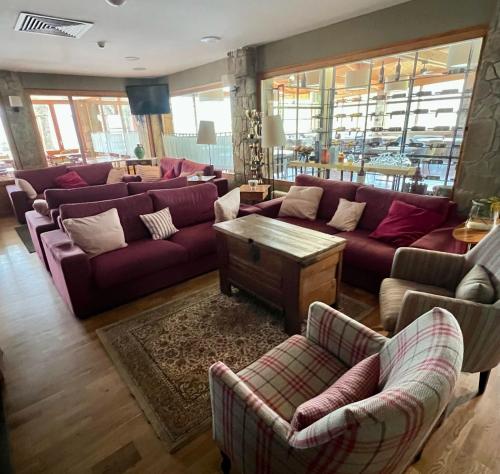 a living room with purple couches and a table at Hostal Pedraforca in Saldés