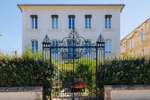 a black gate in front of a white building at La Passerelle du Canal in Sallèles-dʼAude