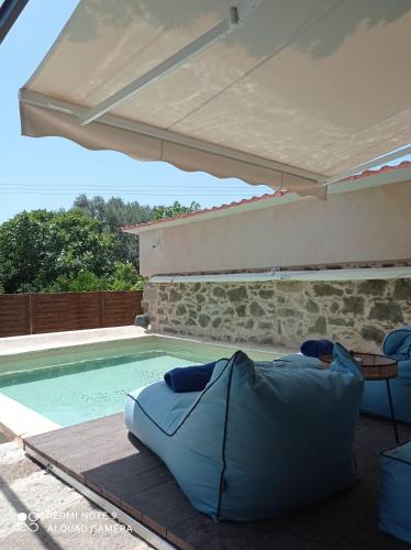 ein Pool mit einem großen Sonnenschirm und einem Pool in der Unterkunft Περιβόλι του Οδυσσέα in Volissos