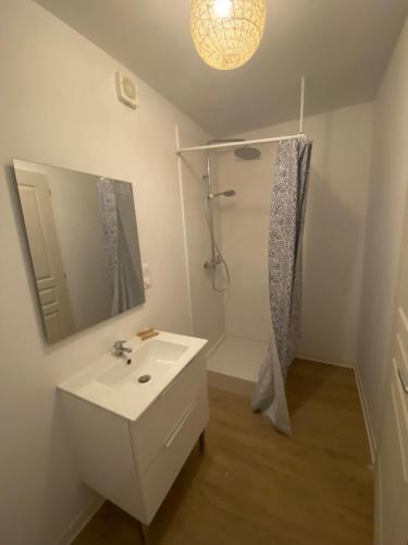 Un baño blanco con ducha y lavabo. en La cigales, en Martigues