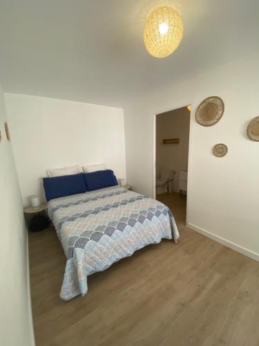 Un dormitorio con una cama con almohadas azules. en La cigales, en Martigues