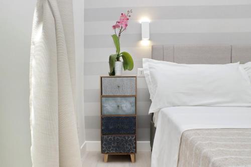a bedroom with a bed and a nightstand with a plant at Gialli Vatican Guesthouse in Rome
