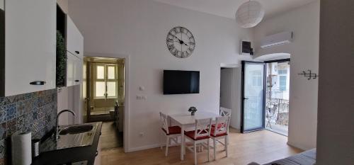 uma sala de estar com uma mesa e um relógio na parede em Apartman Golf em Zagreb