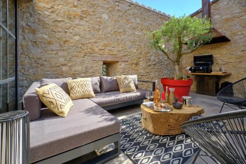 a patio with a couch and a table at Séjour LUXE pour couple avec PISCINE INTÉRIEURE terrasse SPA privé Green de GOLF in Alzonne