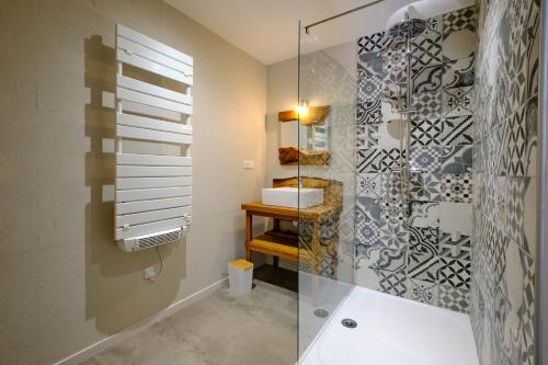 a bathroom with a glass shower and a sink at Loft Industriel privé climatisé Piscine intérieure Terrasse SPA et jardin in Alzonne