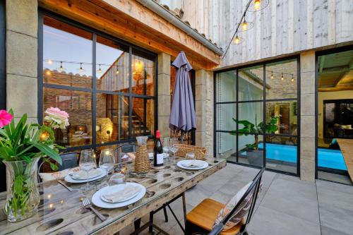 a dining room with a wooden table and chairs at Séjour LUXE pour couple avec PISCINE INTÉRIEURE terrasse SPA privé Green de GOLF in Alzonne