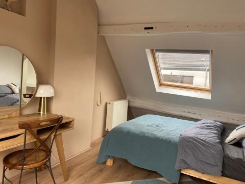 1 dormitorio con cama, escritorio y espejo en Vivegnis, little cosy house, en Lieja