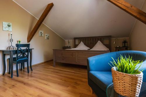 a living room with a blue couch and a bed at Landhotel Rehedyk in Sankt Michaelisdonn