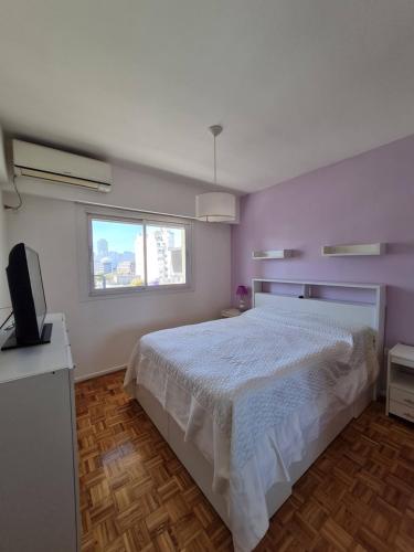ein Schlafzimmer mit einem weißen Bett und einem Fenster in der Unterkunft Excelente departamento en el corazon de San Telmo in Buenos Aires