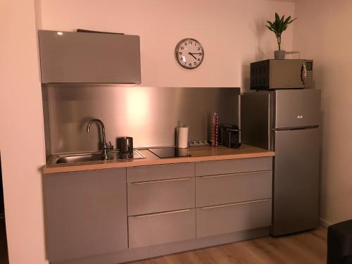 La cuisine est équipée d'un évier, d'un réfrigérateur et d'une horloge. dans l'établissement 2 pièces Hyper Centre Équipé et Confortable Toulon, à Toulon