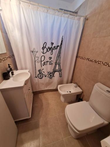 ein Badezimmer mit einem WC, einem Waschbecken und einem Duschvorhang in der Unterkunft Excelente departamento en el corazon de San Telmo in Buenos Aires