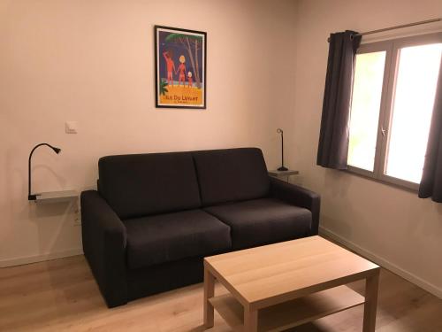 un salon avec un canapé noir et une table dans l'établissement 2 pièces Hyper Centre Équipé et Confortable Toulon, à Toulon